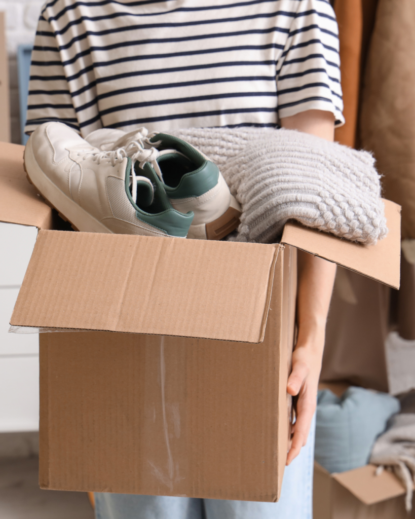 Personne rangeant les affaires non vendues après une vente de garage.